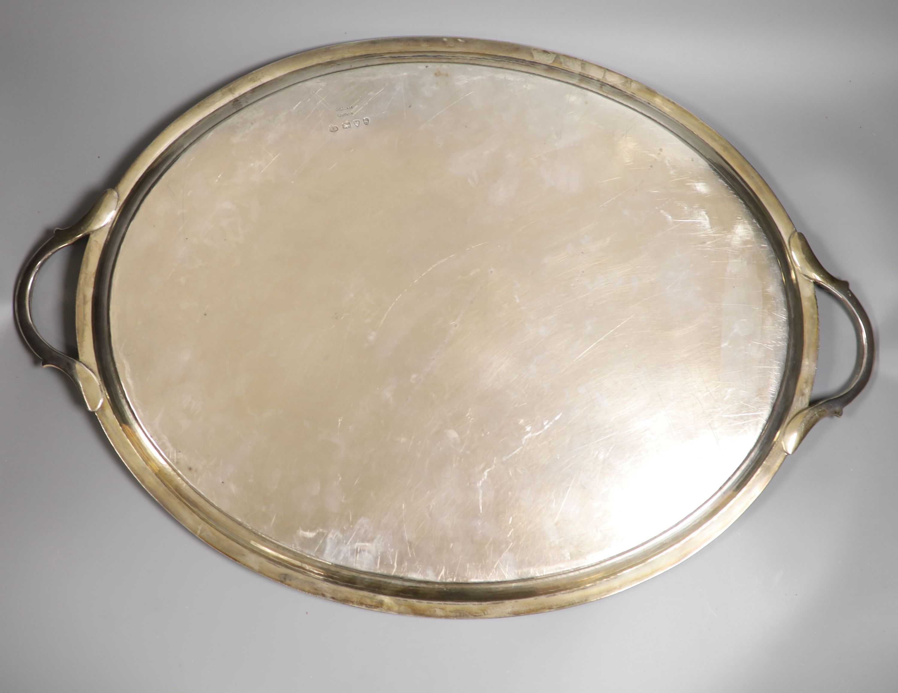 A late Victorian silver oval two handled tea tray, with gadrooned border and engraved inscription, George Gilliam, London, 1893, 62.8cm over handles, 99oz.